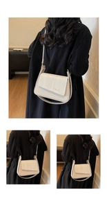 Detail of minimalist beige crossbody bag with woven texture flap and gold fashion lettering