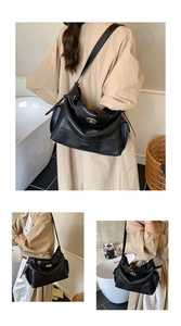 Close-up of black oil wax leather tote bag featuring a metallic oval twist lock detail