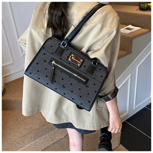 Detail showing the large-capacity black polka dot tote bag with a front zipper pocket