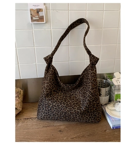 Dettaglio della borsa hobo leopardata con nodi decorativi sulla tracolla e stile vintage