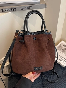 Brown faux suede drawstring bucket bag with black handles and retro style finish