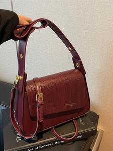 Classic burgundy leather crossbody bag with woven texture flap and wide shoulder strap