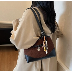 Detail of leopard print tote featuring ethnic beads, bow charm and brown suede texture