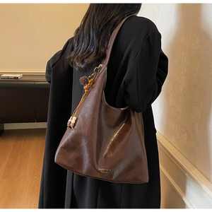 Detailed view of large dark brown hobo bag with vintage leather texture and beaded tassel