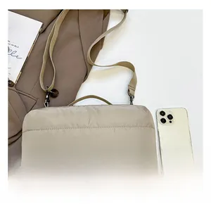 Détail du sac matelassé bicolore beige et marron montrant la taille comparée au téléphone