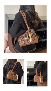Detail view of leopard print tote bag featuring beaded charms and brown leather trim