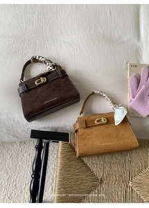 Detalle de bolsos vintage de gamuza con asas de pañuelo de seda y cierres metálicos dorados