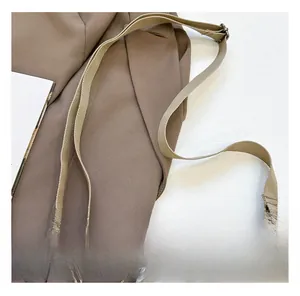 Détail de la bandoulière tissée kaki réglable avec des crochets en métal noir premium