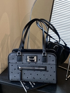 Grey polka dot tote bag with black bow print and leather straps in a mirror scene