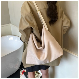 Detail view of the soft apricot hobo bag featuring adjustable strap and golden hardware