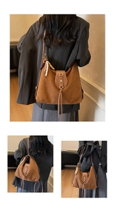 Détail du grand sac à bandoulière en daim marron avec un fermoir décoratif en fleur de métal