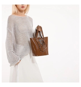 Gothic style brown patent leather bucket bag with silver studs and cross pendant detail