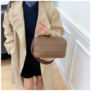 Détail du sac fourre-tout matelassé marron avec texture nylon et bandoulière tissée