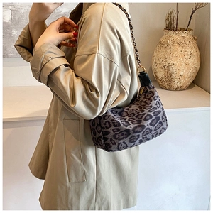 Detail of leopard print shoulder bag featuring chain strap and textured fabric finish