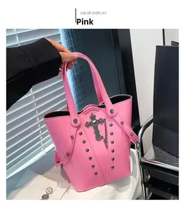 Pink gothic bucket bag with silver cross and metal rivets detail in a lifestyle shot