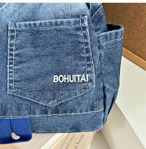 Detailed close-up of gradient denim backpack with white BOHUITAI embroidery on pocket