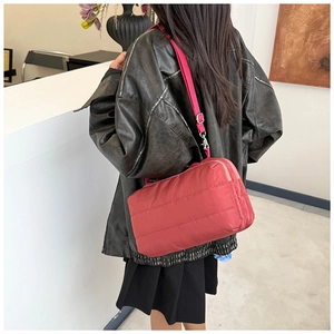 Détail du sac à bandoulière matelassé bordeaux avec sangle en nylon ajustable et boucle argent