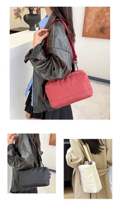 Détail de sacs fourre-tout matelassés en nylon rouge, noir et blanc élégants