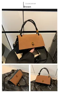 Dettaglio di una borsa bicolore vintage con chiusura in metallo dorato e manico annodato