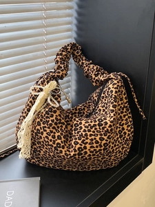 Leopard print canvas tote bag with ruffled handle and pearl lace charm in soft sunlight