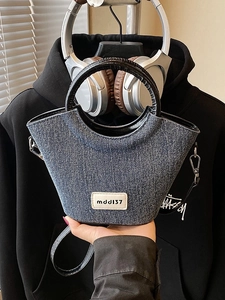 Sac seau minimaliste en denim bleu marine avec poignées noires et bandoulière amovible