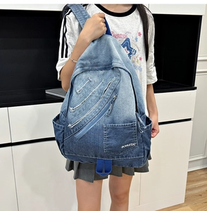 Detail of vintage blue denim backpack featuring frayed edges and white BOHUITAI branding logo