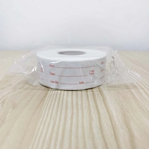 Macro shot of self-adhesive food labels roll in plastic wrap on a wooden background