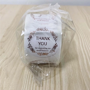 Close-up of rose gold foil Thank You stickers for small business in a roll