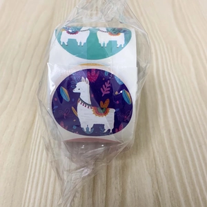 Detail of alpaca theme roll stickers with tropical flowers on wooden background