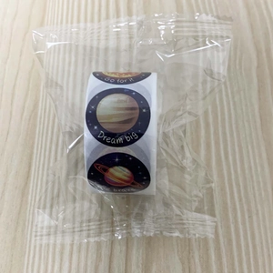 Detail view of round space themed stickers with planets and motivational quotes in a roll
