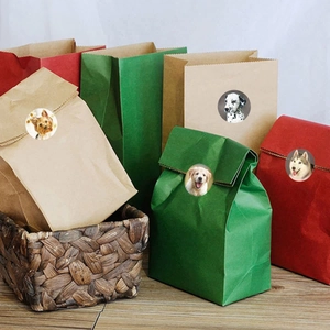 Colorful paper gift bags with realistic dog breed stickers on a rustic wooden table