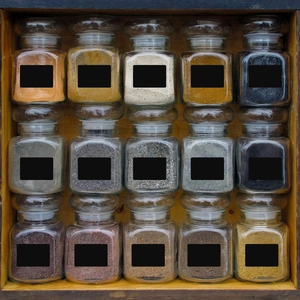 Detail of waterproof chalkboard labels applied to glass spice jars in a wooden box
