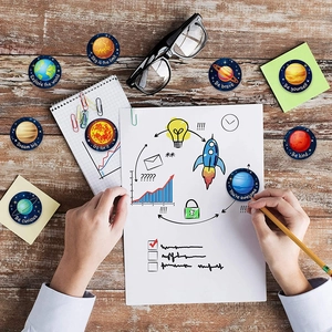 Solar system space stickers with planets and phrases on a rustic wooden desk
