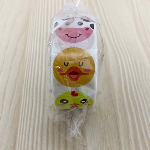 Detail of cartoon animal reward stickers roll in sealed clear packaging on wood table