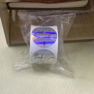 Macro shot of holographic thank you stickers for small business in clear packaging
