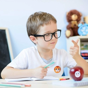 Close-up of cute animal reward stickers applied to a child's shirt and a fresh apple