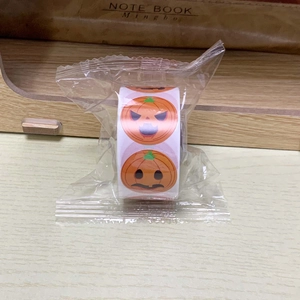 Close-up of a roll of Halloween pumpkin face stickers in original clear packaging