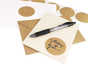 Macro view of kraft paper stickers with Thinking of You text for gift envelope sealing