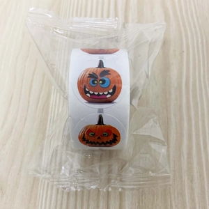 Detail view of 500 count Halloween pumpkin face stickers roll in plastic packaging