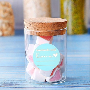 Dettaglio dell'adesivo fatto a mano su un barattolo di vetro con marshmallow rosa e bianchi