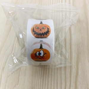 Close-up of a roll of Halloween pumpkin stickers for kids in transparent packaging