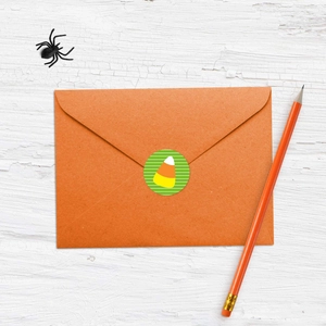 Dettaglio dell'adesivo Candy Corn su busta arancione con decorazioni di Halloween