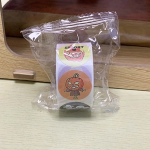 Detail of Halloween stickers roll in plastic packaging on wooden surface