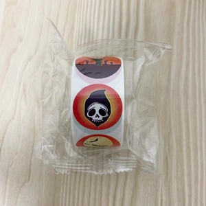 Detail showing a roll of Halloween cartoon stickers in transparent plastic packaging