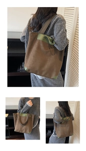 Detail view of large brown suede tote bag with green leather handles and corner accents