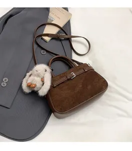 Sac bandoulière en daim marron avec poignée, boucle métal et détail de charm lapin blanc