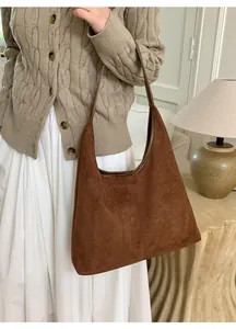 Détail du sac cabas en daim marron foncé avec couture et bandoulière en cuir