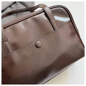 Close-up of retro large-capacity underarm bag featuring oil wax leather and snap pocket