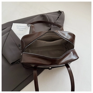 Detail view of the spacious interior with zip pocket in a dark brown leather tote bag