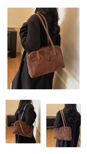 Detail of dark brown matte suede bowling bag with circular button and slim shoulder straps